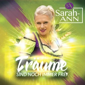 Träume sind noch immer frei” von Sarah-ANN – Sängerin im grünen Dirndl vor leuchtendem Hintergrund