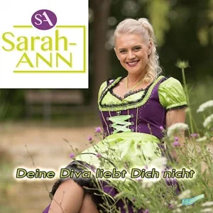 Deine Diva liebt Dich nicht” von Sarah-ANN – Sängerin im Dirndl in einer Blumenwiese